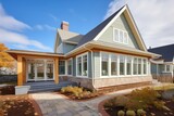 shingle style home with stone accented window wells