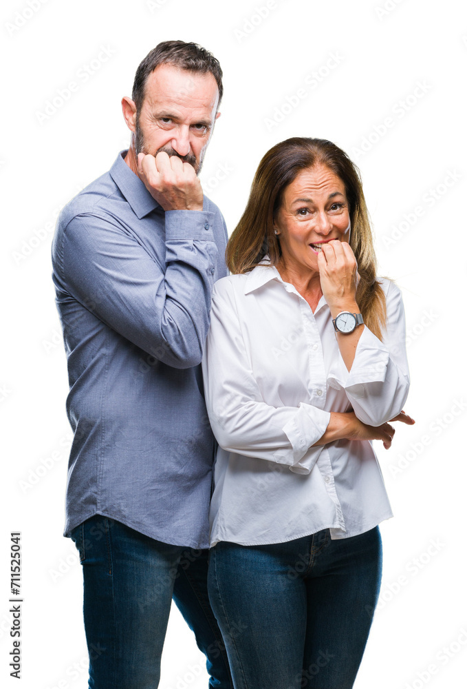 Middle age hispanic business couple over isolated background looking stressed and nervous with hands on mouth biting nails. Anxiety problem. Middle age hispanic business couple over isolated background looking stressed and nervous with hands on mouth biting nails. Anxiety problem.
