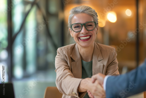 Mulher de terno no escritório dando um aperto de mão com um sorriso  photo