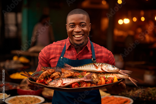 Grilled Seafood Charm: In Luanda, Angola, a Chef Delights in Grilling Fish in an Open-Air Restaurant, Infusing the Atmosphere with Good Disposition and Barbecue Bliss photo