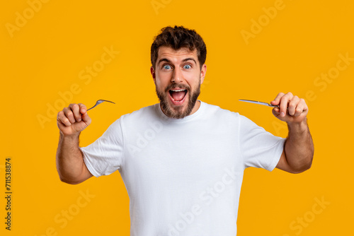 Emotional man holding knife and fork ready to eat, studio photo