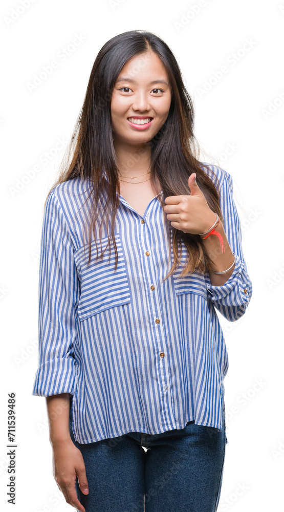Young asian woman over isolated background doing happy thumbs up gesture with hand. Approving expression looking at the camera with showing success. Young asian woman over isolated background doing happy thumbs up gesture with hand. Approving expression looking at the camera with showing success.