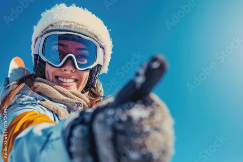 A woman wearing a white hat and goggles enthusiastically giving a thumbs up gesture. This image can be used to convey approval, success, positivity, or encouragement