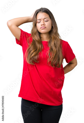 Young beautiful brunette woman wearing red t-shirt over isolated background confuse and wonder about question. Uncertain with doubt, thinking with hand on head. Pensive concept.