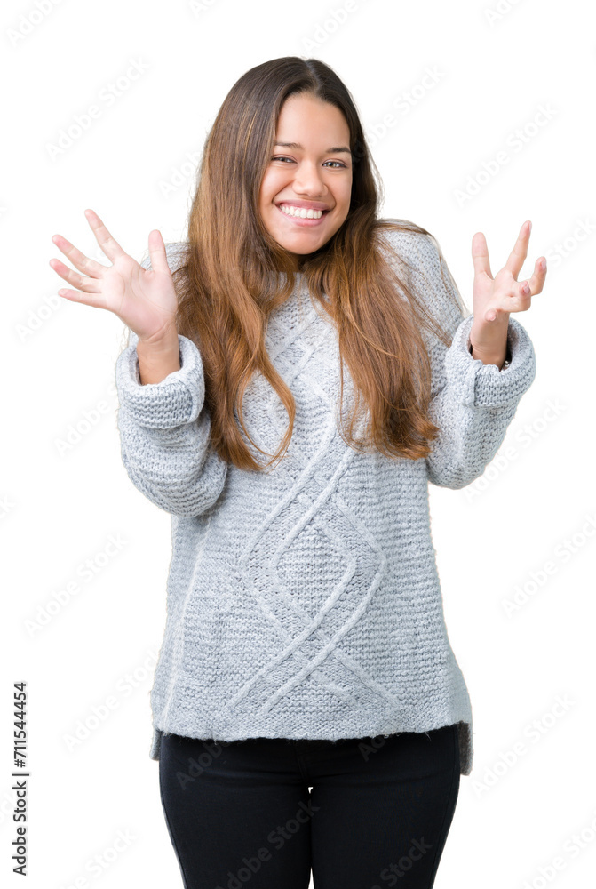 Young beautiful brunette woman wearing sweater over isolated background celebrating crazy and amazed for success with arms raised and open eyes screaming excited. Winner concept Young beautiful brunette woman wearing sweater over isolated background celebrating crazy and amazed for success with arms raised and open eyes screaming excited. Winner concept