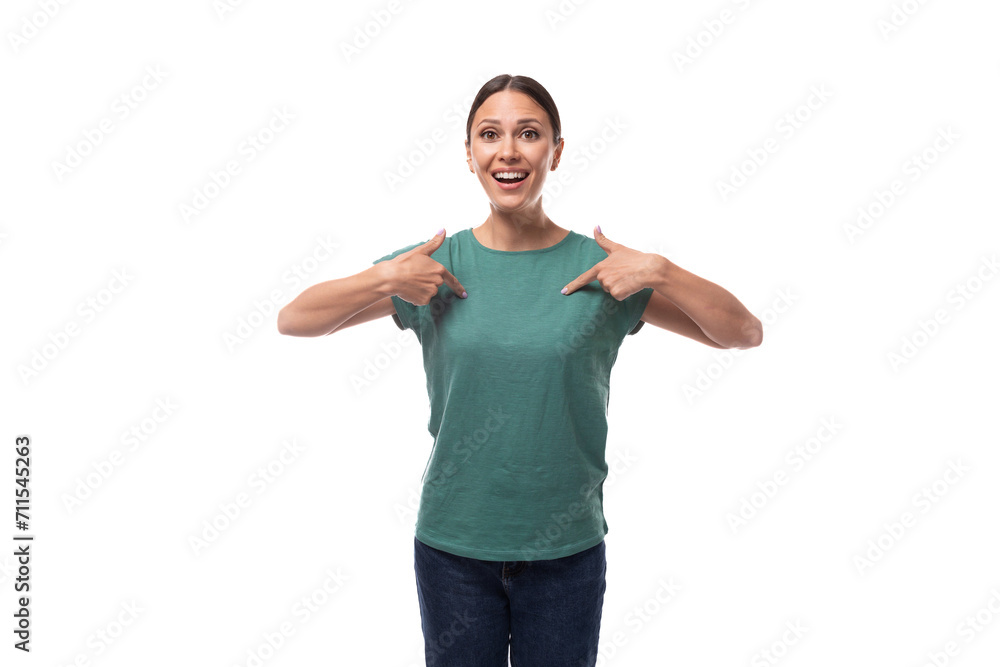 A 30 year old positive European brunette woman with a ponytail is dressed in a green T-shirt and jeans talks about advertising A 30 year old positive European brunette woman with a ponytail is dressed in a green T-shirt and jeans talks about advertising