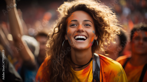 A girl in orange smiles in the crowd at the Holi festival. © Oksana Tryndiak