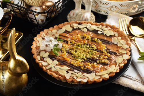 Easter caramel Mazurek tart on black table with white and golden decors