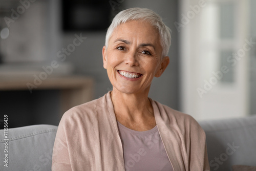 older woman with short haircut and gray hair posing indoors photo