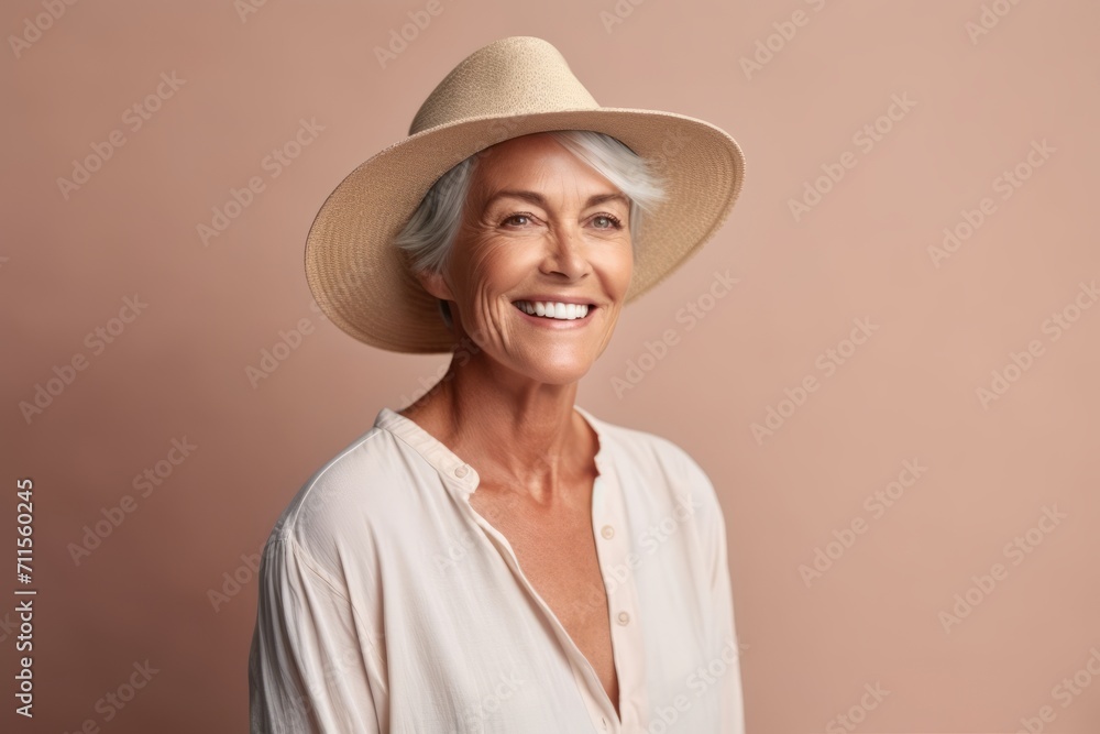 Portrait of smiling senior woman in straw hat on beige background Portrait of smiling senior woman in straw hat on beige background
