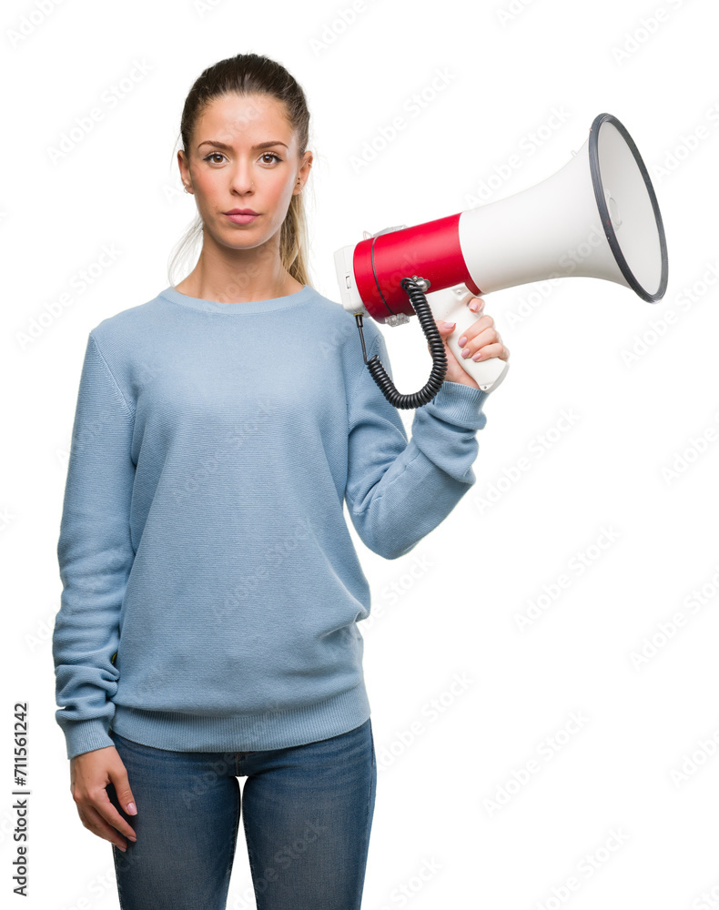 Beautiful young woman holding megaphone with a confident expression on smart face thinking serious Beautiful young woman holding megaphone with a confident expression on smart face thinking serious