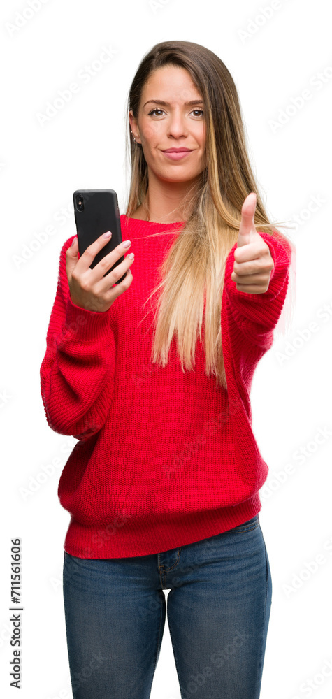 Beautiful young woman using smartphone happy with big smile doing ok sign, thumb up with fingers, excellent sign Beautiful young woman using smartphone happy with big smile doing ok sign, thumb up with fingers, excellent sign