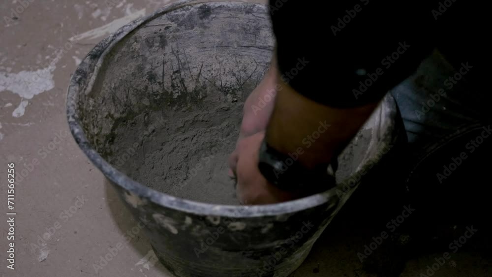 worker hands mixes cement powder or glue in a bucket for construction or renovation work worker hands mixes cement powder or glue in a bucket for construction or renovation work
