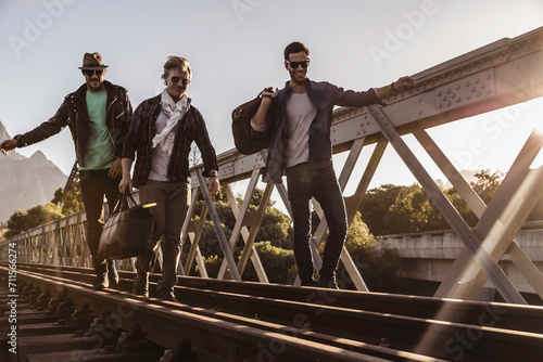 Group of friends walking across train bridge and hanging out hobo style. Paarl, South Africa photo