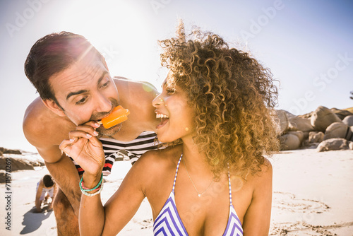 Mixed race couple having fun playing on the beach. Cape Town, South Africa