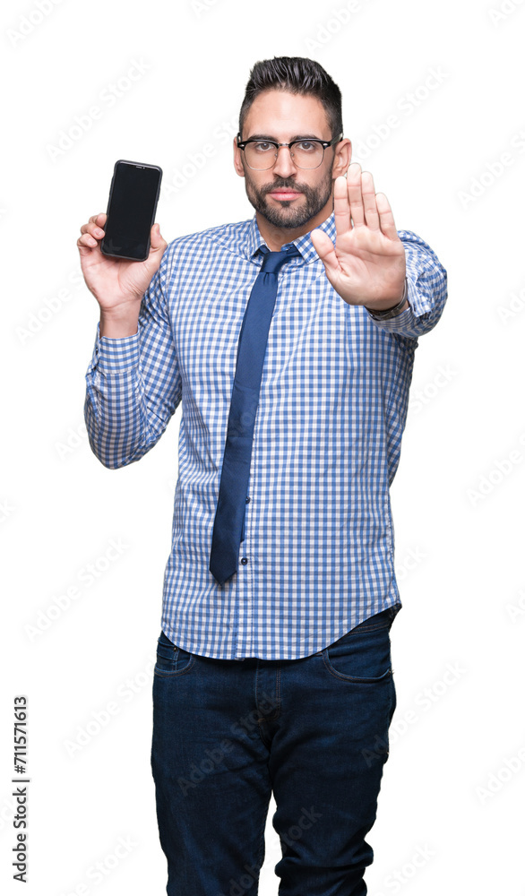 Young business man showing smartphone screen over isolated background with open hand doing stop sign with serious and confident expression, defense gesture Young business man showing smartphone screen over isolated background with open hand doing stop sign with serious and confident expression, defense gesture