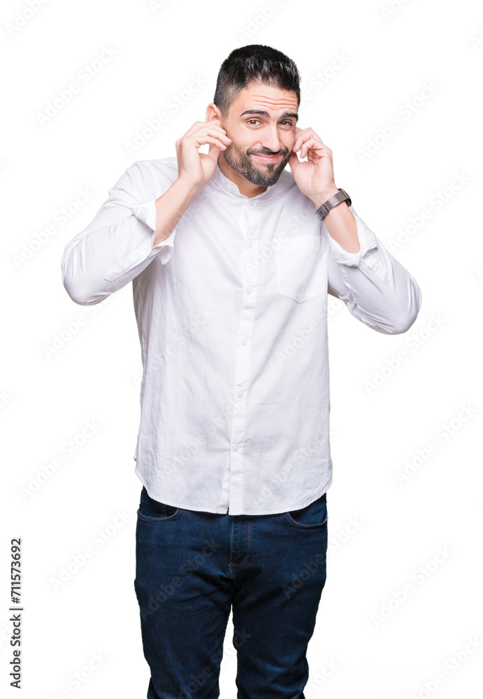 Young business man over isolated background covering ears with fingers with annoyed expression for the noise of loud music. Deaf concept. Young business man over isolated background covering ears with fingers with annoyed expression for the noise of loud music. Deaf concept.