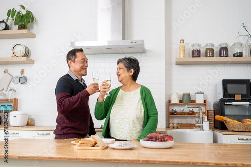 Mature couple have spending time with wine and dance together in kitchen