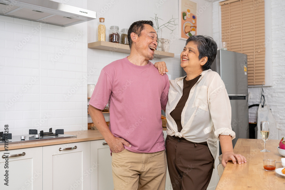 Cheerful Mature couple have spending time together in kitchen Cheerful Mature couple have spending time together in kitchen