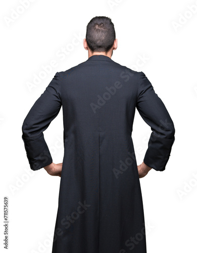 Young Christian priest over isolated background standing backwards looking away with arms on body