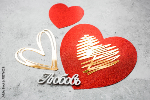 Festive background with red and gold hearts and the word in Russian: \