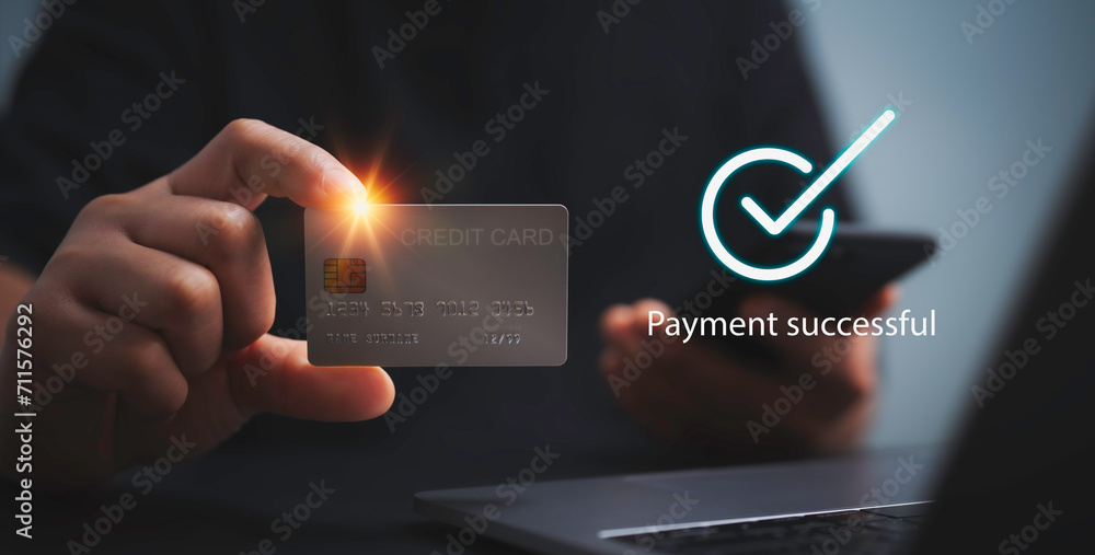 Payment successful concept.Hand holding credit card and smartphone with Payment successful.Online Money Transfer Confirmed.Concept of e-commerce and online banking, payment transfer.. - obrazy, fototapety, plakaty 