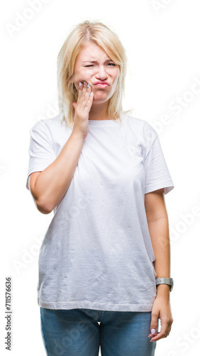 Young beautiful blonde woman wearing white t-shirt over isolated background touching mouth with hand with painful expression because of toothache or dental illness on teeth. Dentist concept.