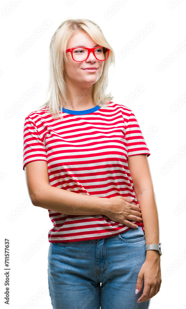 Young beautiful blonde woman wearing glasses over isolated background looking away to side with smile on face, natural expression. Laughing confident. Young beautiful blonde woman wearing glasses over isolated background looking away to side with smile on face, natural expression. Laughing confident.
