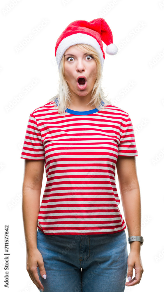 Young beautiful blonde woman wearing christmas hat over isolated background afraid and shocked with surprise expression, fear and excited face.