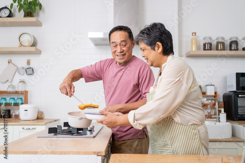 Mature asian Couples enjoy to cooking meal together in kitchen.