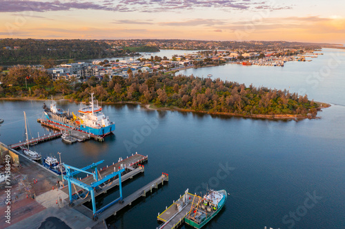 Aerial view of a ship at a wharf alongside a ship repair dock and waterfront area at sunset photo