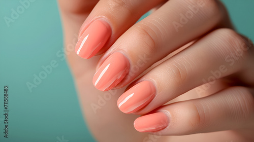 Close-up of well-manicured nails with glossy peach fuzz nail polish.