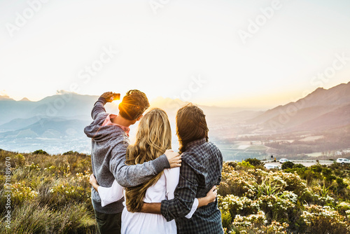 Group of friends taking a selfie in the mountains at sunset