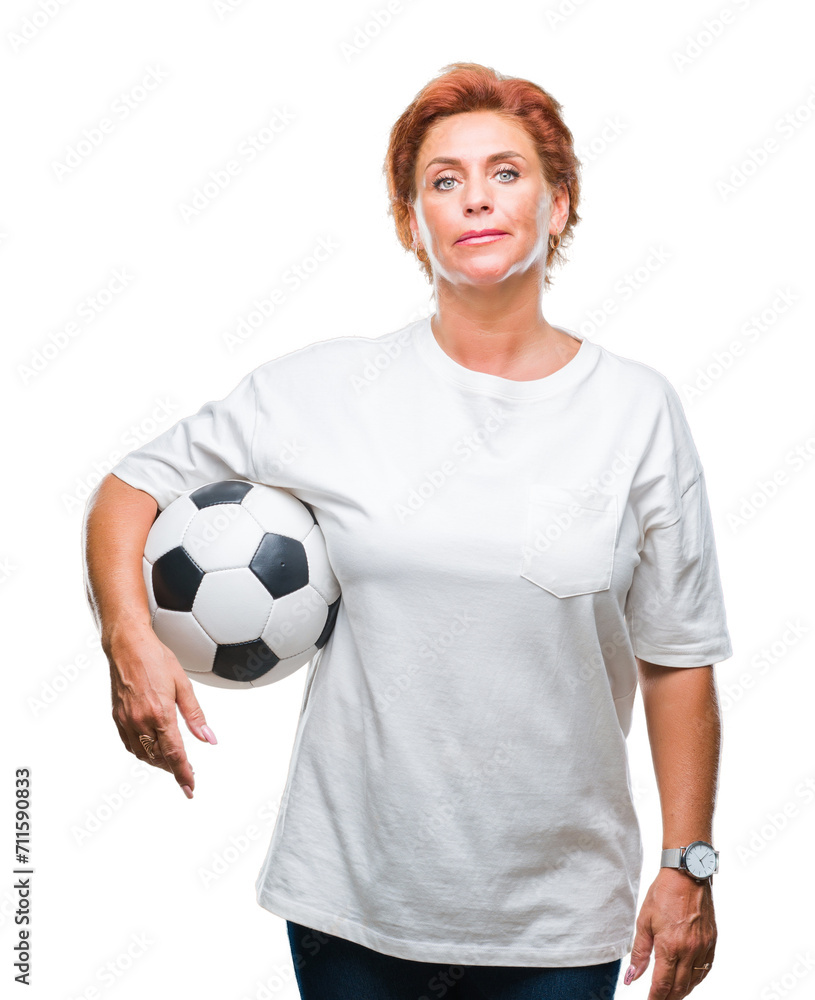 Atrractive senior caucasian redhead woman holding soccer ball over isolated background with a confident expression on smart face thinking serious