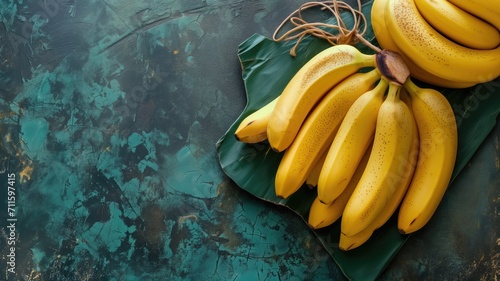 Bunch of bananas on banana leaf with a turquoise textured background