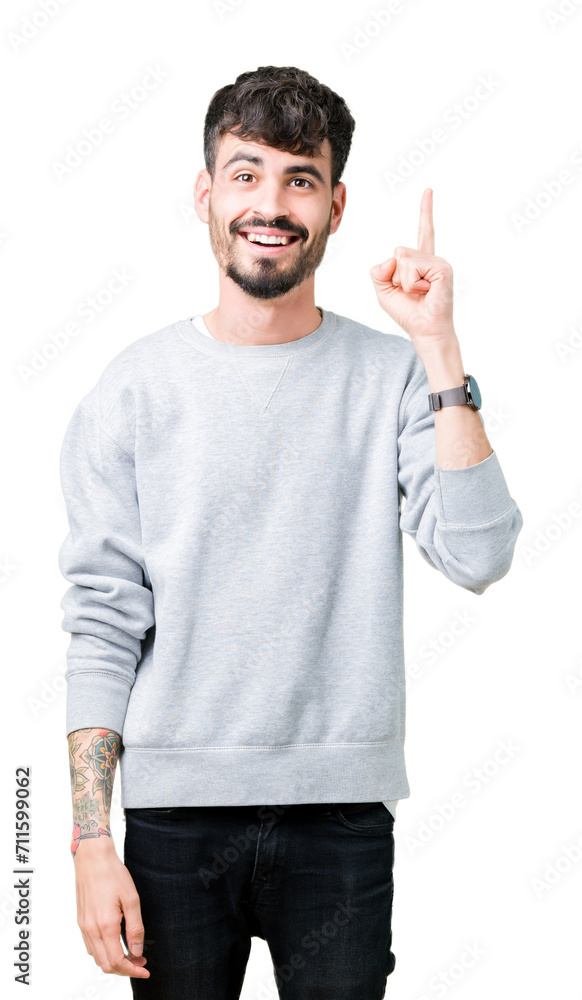 Young handsome man wearing sweatshirt over isolated background pointing finger up with successful idea. Exited and happy. Number one. Young handsome man wearing sweatshirt over isolated background pointing finger up with successful idea. Exited and happy. Number one.