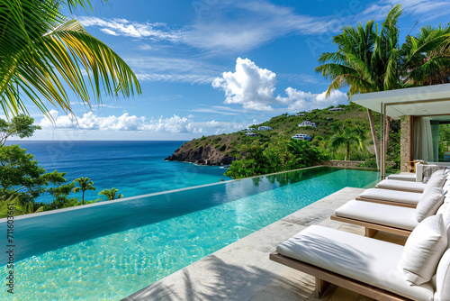 Luxury poolside loungers overlooking tropical ocean and clear blue sky photo