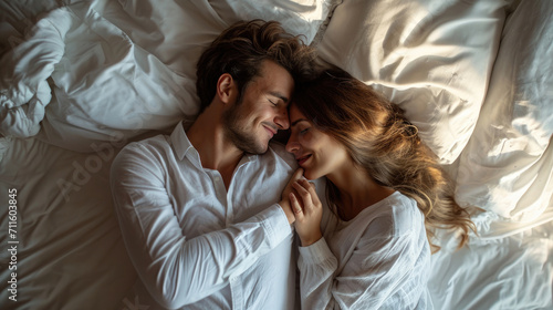 Top view beautiful young couple two family in casual white clothes lying in bed sleep woman hands folded under head on man shoulder relax spend time together in bedroom lounge home in own room house photo