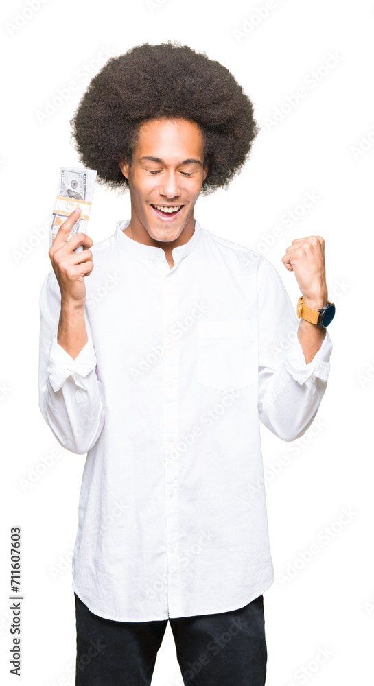 Young african american man with afro hair holding bunch of dollars screaming proud and celebrating victory and success very excited, cheering emotion Young african american man with afro hair holding bunch of dollars screaming proud and celebrating victory and success very excited, cheering emotion