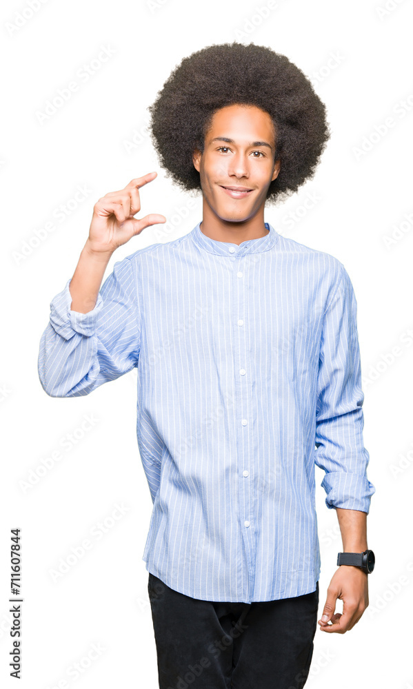 Young african american man with afro hair smiling and confident gesturing with hand doing size sign with fingers while looking and the camera. Measure concept. Young african american man with afro hair smiling and confident gesturing with hand doing size sign with fingers while looking and the camera. Measure concept.