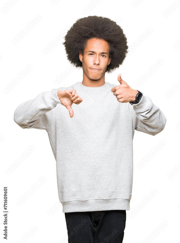 Young african american man with afro hair wearing sporty sweatshirt Doing thumbs up and down, disagreement and agreement expression. Crazy conflict Young african american man with afro hair wearing sporty sweatshirt Doing thumbs up and down, disagreement and agreement expression. Crazy conflict
