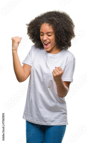 Young afro american woman over isolated background very happy and excited doing winner gesture with arms raised, smiling and screaming for success. Celebration concept.