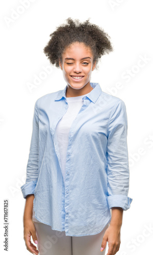 Young afro american woman over isolated background winking looking at the camera with sexy expression, cheerful and happy face.