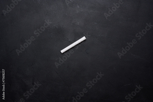 Empty chalk board and piece of white chalk