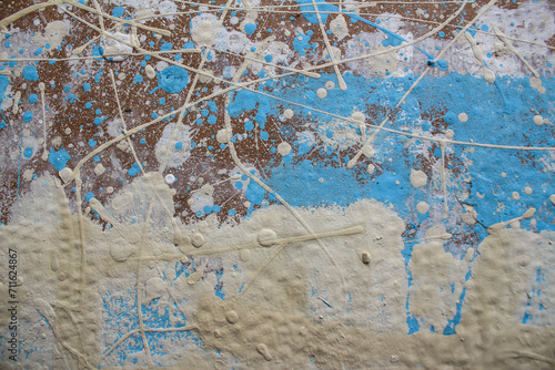 Abstract spots, drops of yellow blue white paint on a brown wooden surface