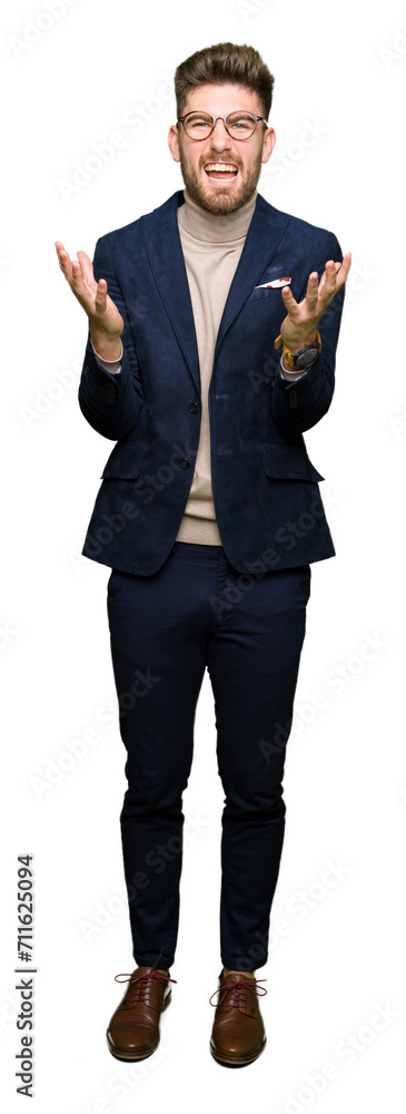 Young handsome business man wearing glasses celebrating mad and crazy for success with arms raised and closed eyes screaming excited. Winner concept Young handsome business man wearing glasses celebrating mad and crazy for success with arms raised and closed eyes screaming excited. Winner concept