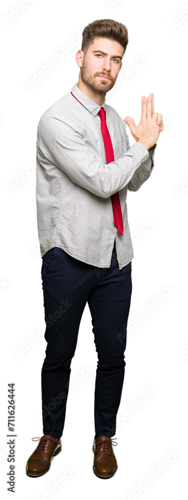 Young handsome business man Holding symbolic gun with hand gesture, playing killing shooting weapons, angry face Young handsome business man Holding symbolic gun with hand gesture, playing killing shooting weapons, angry face