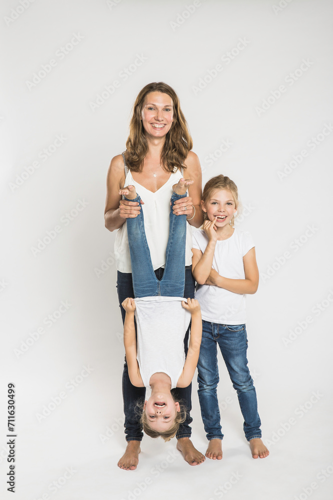 Portrait of mother with two children in studio with white background. Portrait of mother with two children in studio with white background.