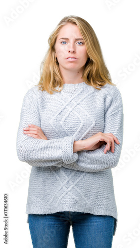 Beautiful young woman wearing winter sweater over isolated background skeptic and nervous, disapproving expression on face with crossed arms. Negative person.