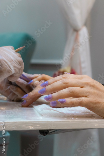 Manicure pintando unha de cliente, cuidado estético photo